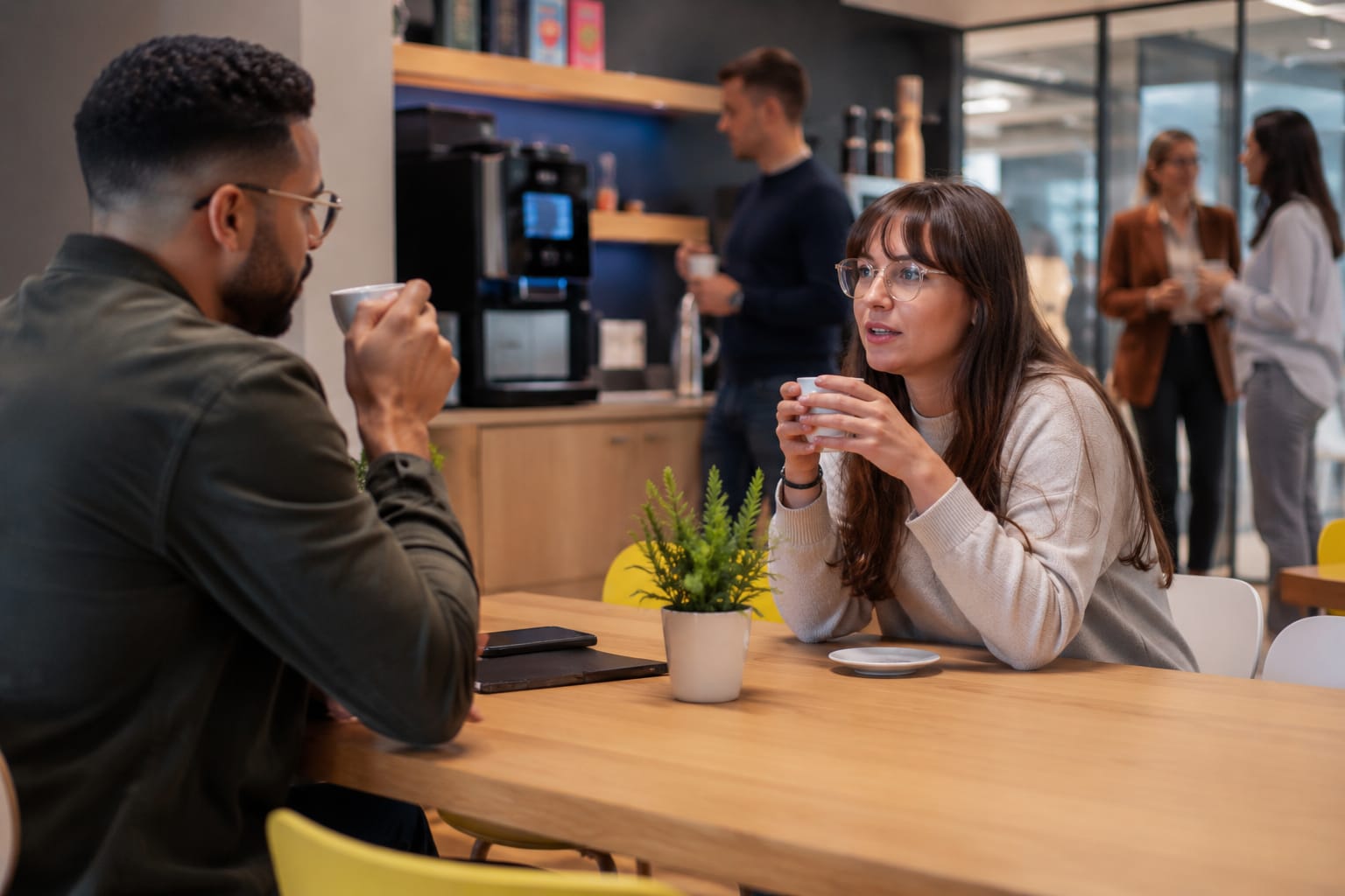 Deux professionnels échangent autour d’un café dans un espace de travail